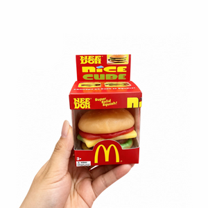 Squishy burger fidget toy pulled apart into five soft layers — bun, tomato, cheese, patty and lettuce