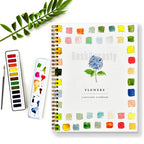 Desk Dynasty watercolor workbook with color swatches, watercolor set, and paintbrushes on a white background.
