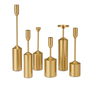 Set of gold candle holders of various shapes and sizes on a white background
