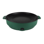 Electric frying pan sizzling with vegetables on a kitchen counter.