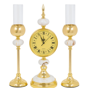 Gold clock with candle holders on a white background