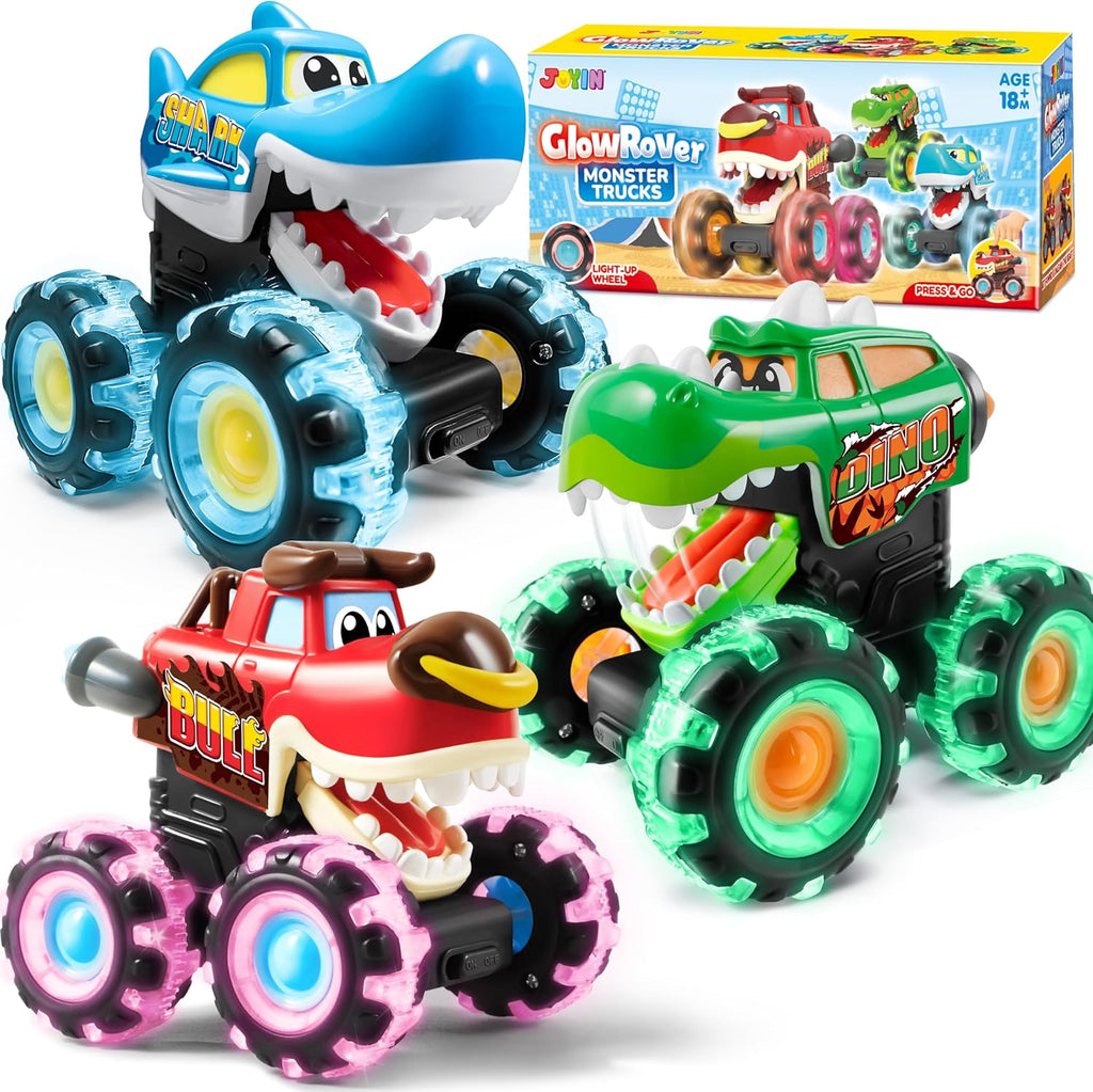 Toy monster trucks with colorful designs and a box in the background