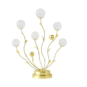 Decorative lamp with gold branches and white spherical elements on a white background