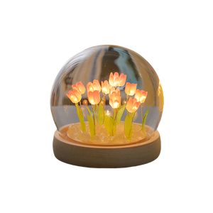 Decorative lamp with glowing flowers inside a transparent dome on a white background