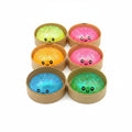 Set of colorful slime balls with smiling faces in brown containers on a white background