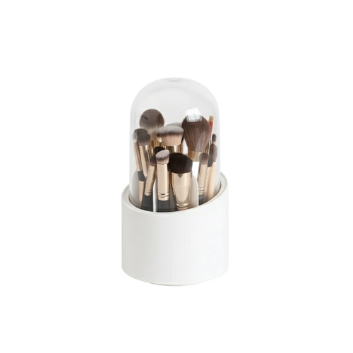 Set of makeup brushes in a white holder with a clear dome on a white background